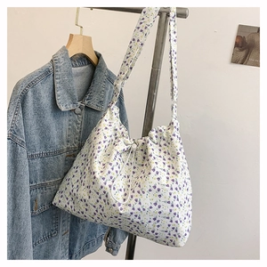 Vue détaillée du sac bandoulière floral en toile avec motifs violets et fermeture à cordon