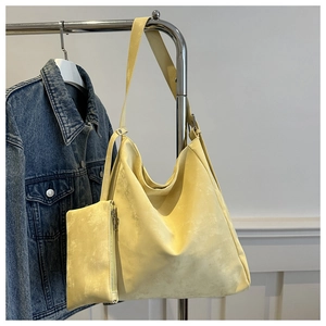 Detail view of a pale yellow hobo shoulder bag with matching zipper pouch and strap