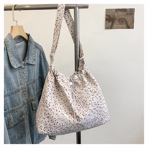 Détail du sac cabas floral à cordon avec bandoulière réglable et motif de pétales