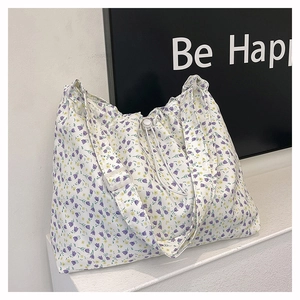 Gros plan détaillé du sac à bandoulière fleuri avec motifs de fleurs violettes et jaunes