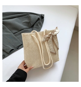 Détail du sac cabas en paille blanc cassé avec anses en corde épaisse et foulard en soie