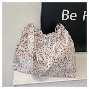 Détail du sac cabas en toile fleurie avec cordon de serrage et boucle en résine réglable