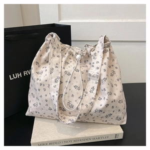 Détail du sac cabas floral avec motifs de fleurs bleues et fermeture à cordon réglable