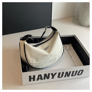 Detail of white moon bag with black trim and silver logo inside a premium gift box