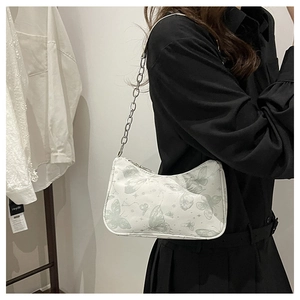 Détail du sac à bandoulière blanc avec motif papillon et chaîne en métal argenté