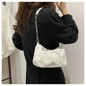 Détail du sac sous les aisselles en croissant blanc avec imprimé papillon et chaîne