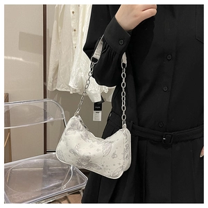 Détail du sac demi-lune blanc avec imprimé papillon et bandoulière chaîne argentée