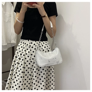 Detail of white butterfly printed bag showing the zipper and silver chain strap