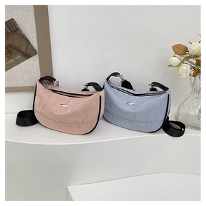 Detail of light pink and blue pleated crescent bags with black straps on a white display