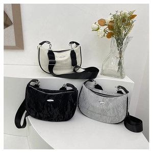 Three half-moon dumpling bags in cream, black and silver with wide fabric straps