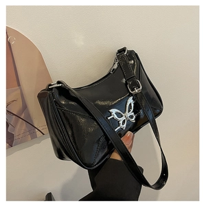 Dettaglio della borsa a spalla in pelle verniciata nera con fibbia a farfalla metallica