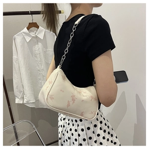 Close-up of creamy white faux leather hobo bag with pink floral print and silver chain strap