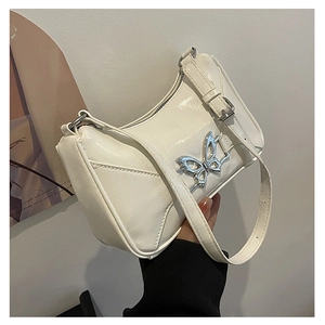 Dettaglio borsa baguette bianca con decorazione a farfalla argentata e tracolla regolabile