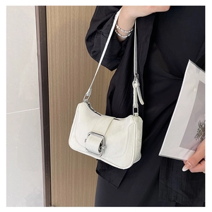 Close-up of a white PU leather underarm bag with a large silver buckle on a stylish model