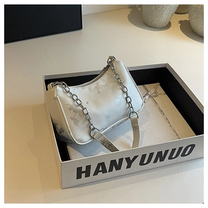 Detail view of white floral chain bag inside a premium gift box with elegant ribbons