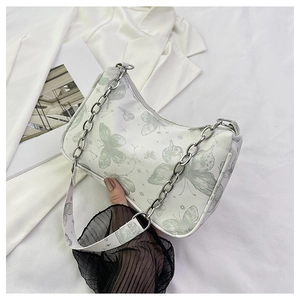 Détail du sac baguette blanc à motif papillon avec chaîne argentée et bandoulière
