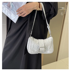 Close-up of silver pleated underarm bag with large metal buckle and textured finish