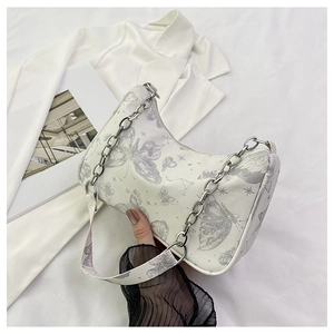 Détail du sac bandoulière blanc avec imprimé papillon et chaîne en métal argenté