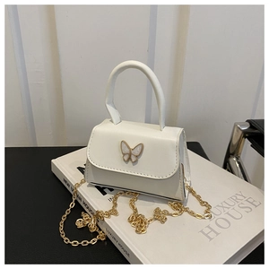 Detail of white PU leather mini flap bag with golden butterfly buckle and chain strap