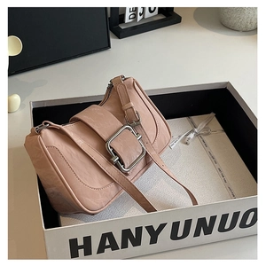 Pink shoulder bag detail showing wrinkled leather texture and a large silver metal buckle