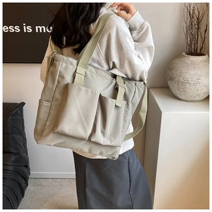 Detail of a large capacity light sage canvas tote with adjustable strap and dual pockets