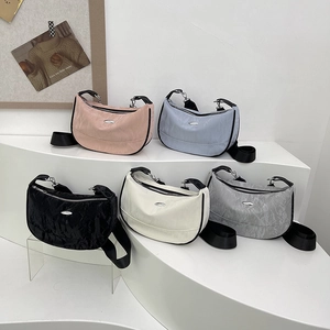 Large crescent crossbody bags in various colors with pleated texture and wide straps