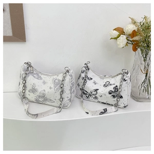 Détail des sacs bandoulière imprimé papillon avec chaîne argentée et sangle en tissu