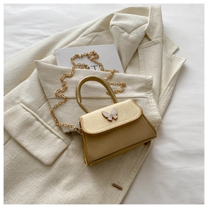 Close-up of golden bow accent and metallic PU leather texture on crossbody bag