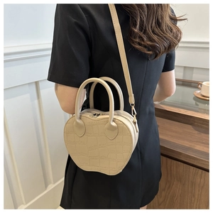Chic apple-shaped crossbody bag with crocodile pattern and round handles on model
