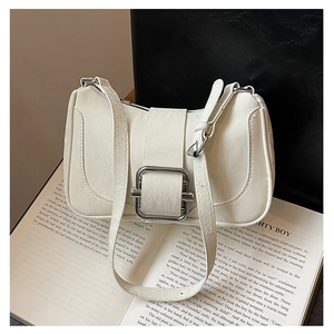 Detail view of cream shoulder bag with large silver square buckle and leather texture