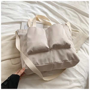 Detail view of large beige oxford tote bag with two spacious front pockets on soft fabric