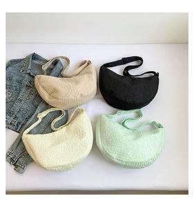 Dettaglio di quattro borse a mezzaluna plissettate in beige nero bianco e verde menta