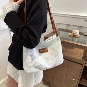 Elegant light blue geometric textured shoulder bag with brown leather straps and minimal design