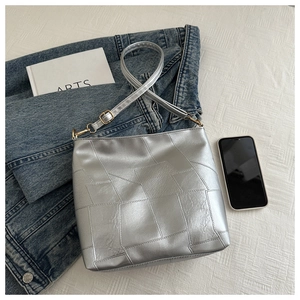 Details der silbernen Patchwork-Handtasche mit PU-Lederstruktur und Gurt