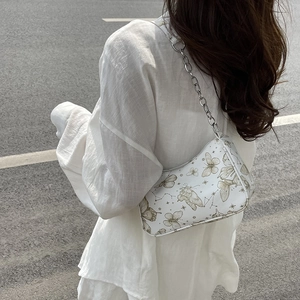 Sac à bandoulière blanc minimaliste avec imprimé papillon et chaîne en argent porté