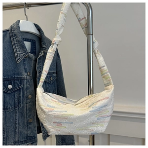 Detail showing white half-moon shoulder bag with colorful embroidery and FF embossed pattern