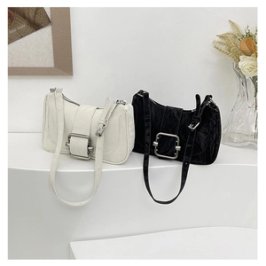 Detail of vintage pleated shoulder bags with large metal square buckles in black and cream