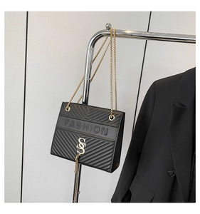 Detail der schwarzen Steppledertasche mit goldenem FASHION-Logo und Fransenquaste