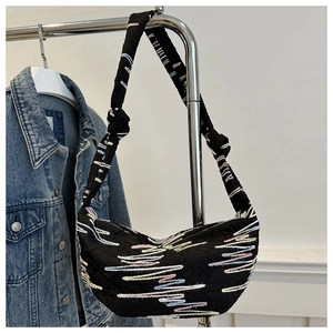 Detail of black crescent shoulder bag with colorful wavy embroidery and knot strap