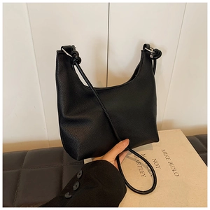 Detail of black lychee grain shoulder bag featuring silver rings and knot handle accents