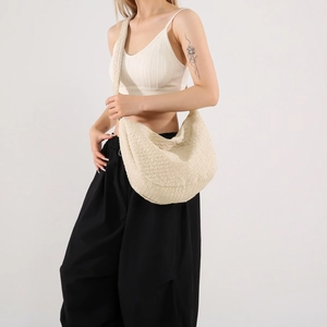 Borsa hobo beige minimalista con trama plissettata indossata come borsa a tracolla alla moda