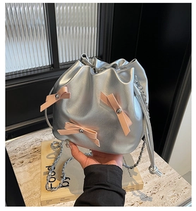 Sac seau métallisé argenté avec nœuds roses et détail de bandoulière en chaîne