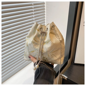 Detailed shot of Jacquard bucket bag with floral patterns, silver chain and pearl tassels