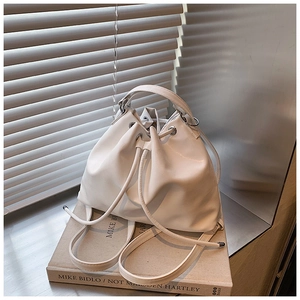 Detail of white leather bucket bag with drawstring closure on a magazine background