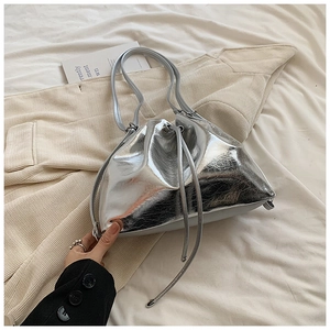 Detailed view of silver bucket bag showing soft mirrored leather and drawstring closure