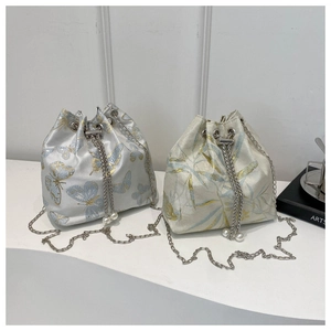 Detail of embroidered drawstring bucket bags with floral patterns and pearl chain straps