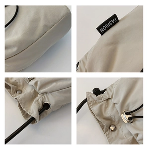 Detailed close-up of beige nylon bag stitching, drawstring metal eyelets and fashion tag