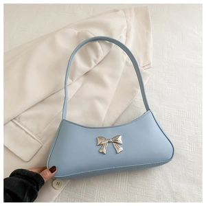 Detail of light blue faux leather baguette bag with silver metallic bow and shoulder strap