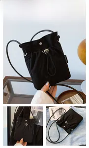 Detail of black drawstring crossbody phone bag with metal buckle and fashion woven label