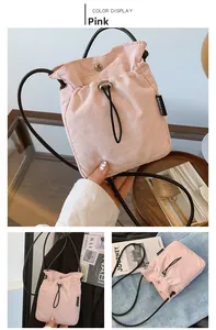 Detail of pink nylon crossbody bag with drawstring closure and fashion woven label